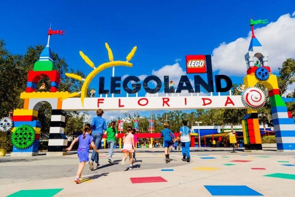 Kids excitedly running towards the entrance to Legoland Florida.