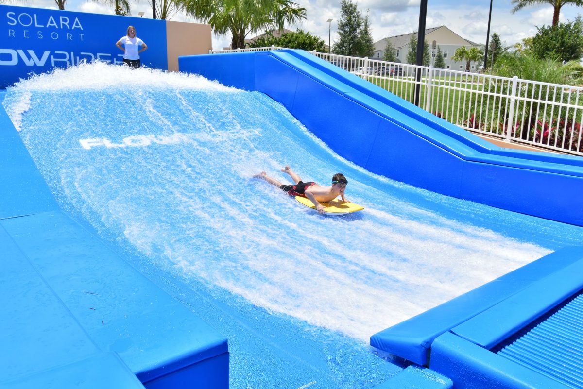Boy enjoying flowrider surf machine.