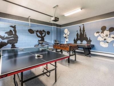 Disney themed game room showing ping pong, foosball, and a pool table.