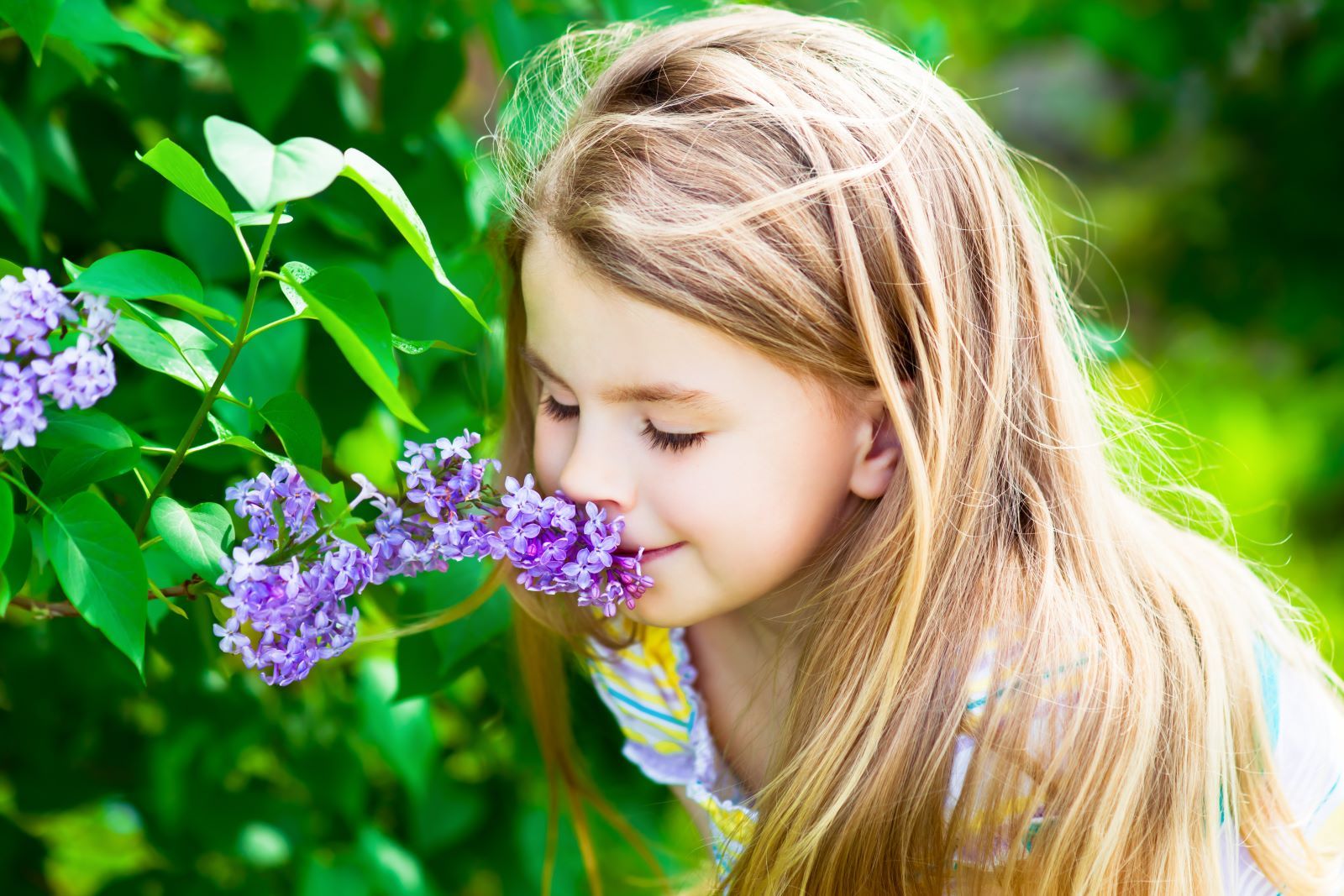 child smelling flowers