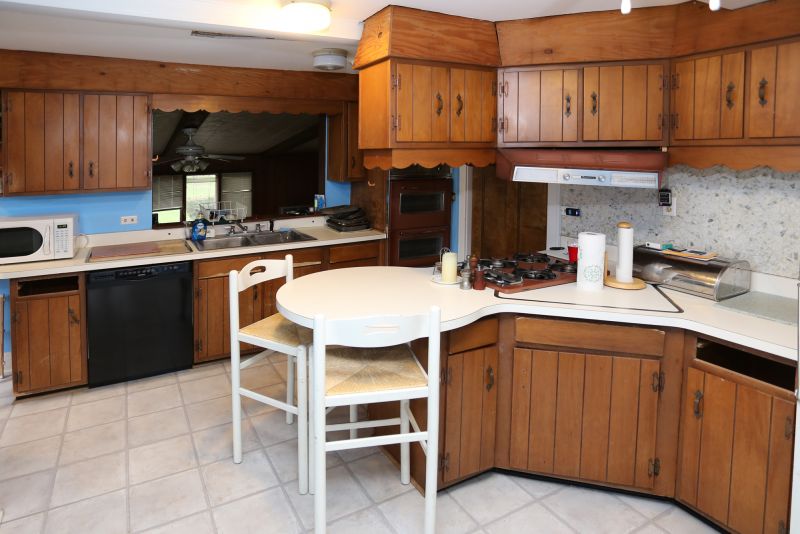 Picture of old kitchen representing vacation home that needs updating. 