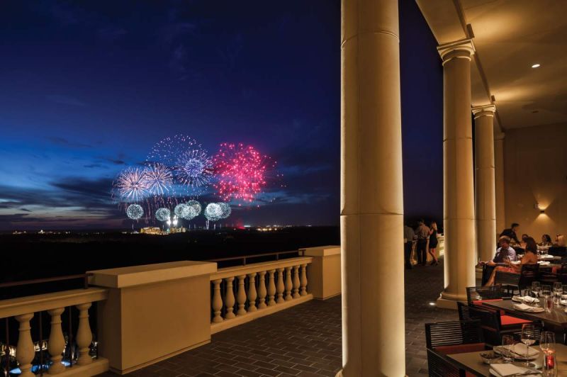 View of Disney firework show from a rooftop bar and restaurant