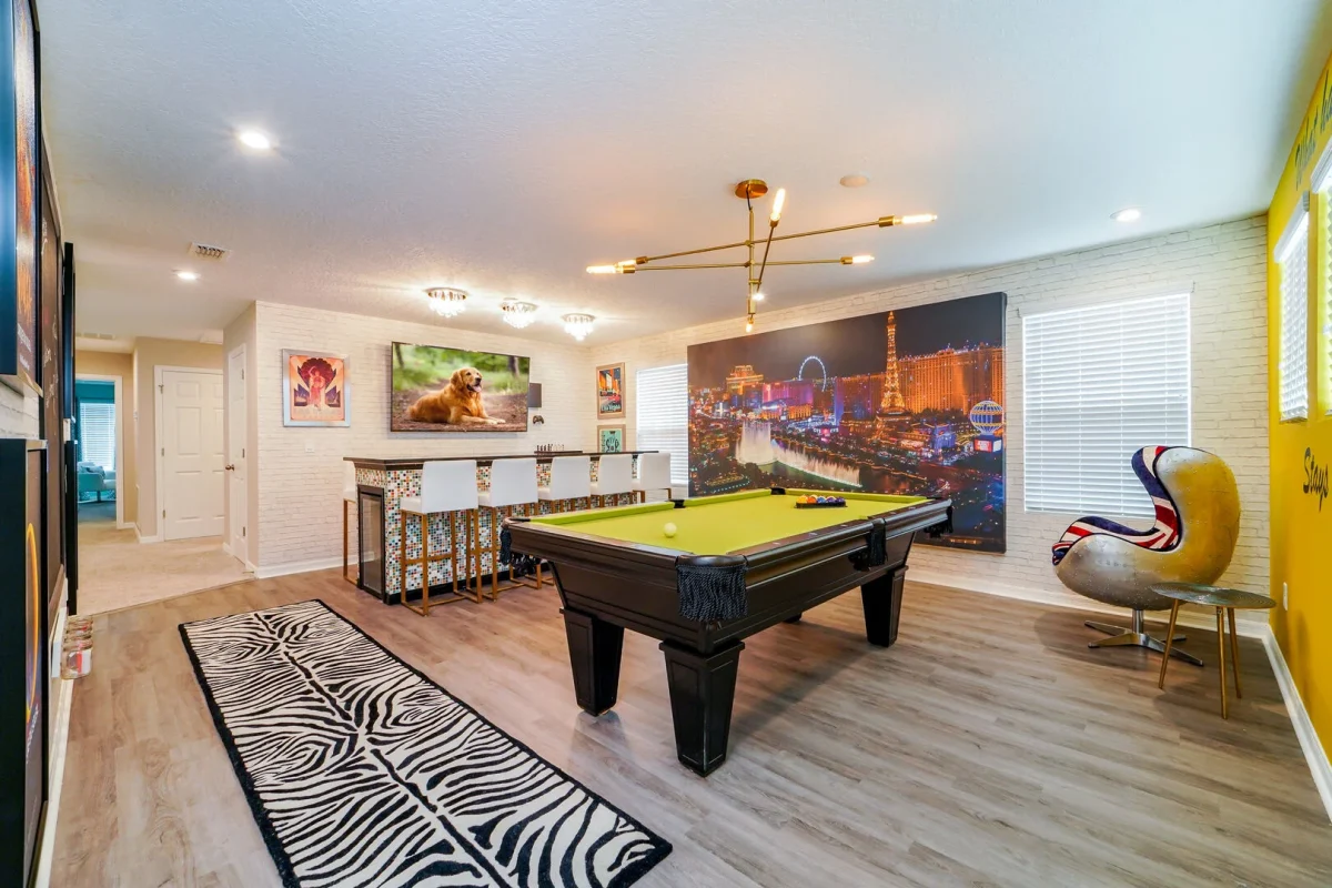 Modern game room with pool table, bar seating, and stylish décor inside Central Florida vacation rental. 