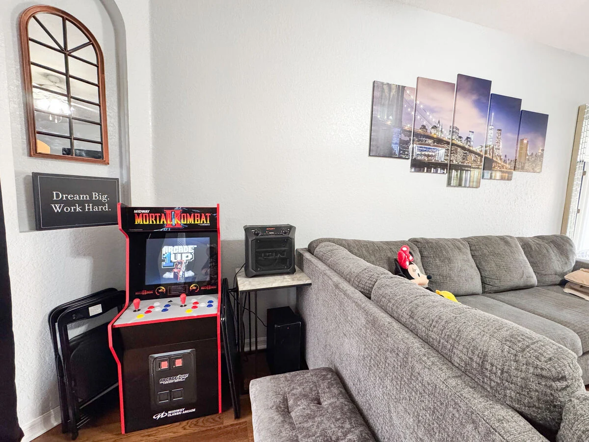 Living room with arcade game, sectional sofa, and entertainment area in a Florida vacation rental home near Disney.