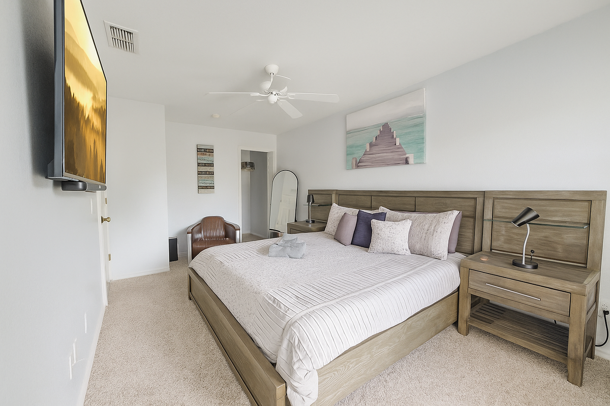 Primary bedroom in a Florida vacation rental with a king bed, TV, and comfortable modern furnishings. 