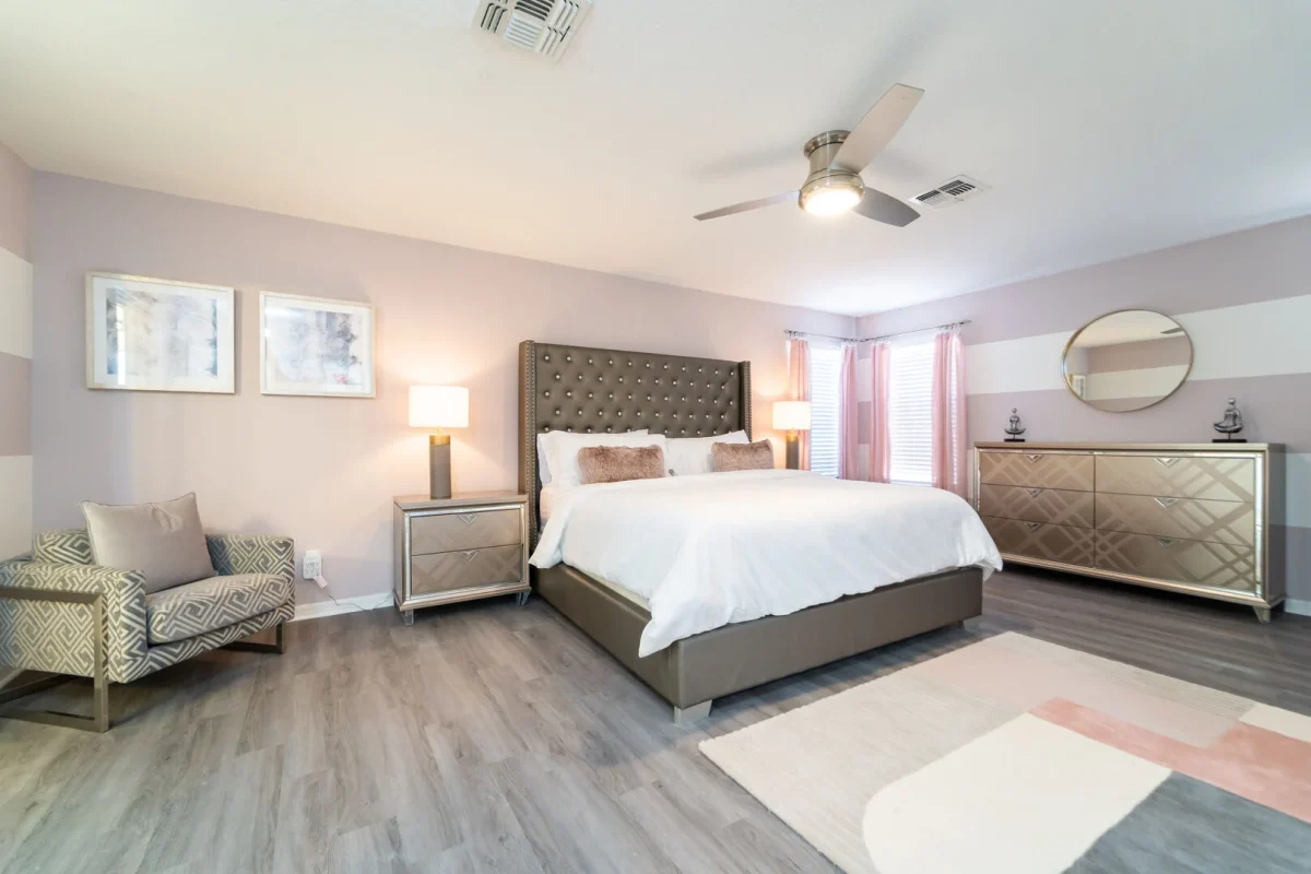 Bright and stylish primary bedroom with a comfortable king bed, soft neutral décor, and plenty of natural light. Perfect for unwinding after a full day of Florida adventures. 