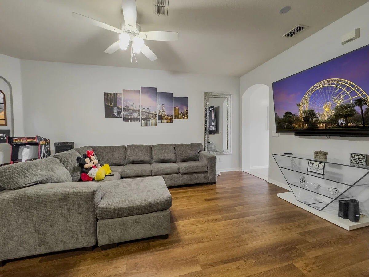 Spacious living room in a Florida vacation rental with sectional sofa, large TV, and comfortable family seating.