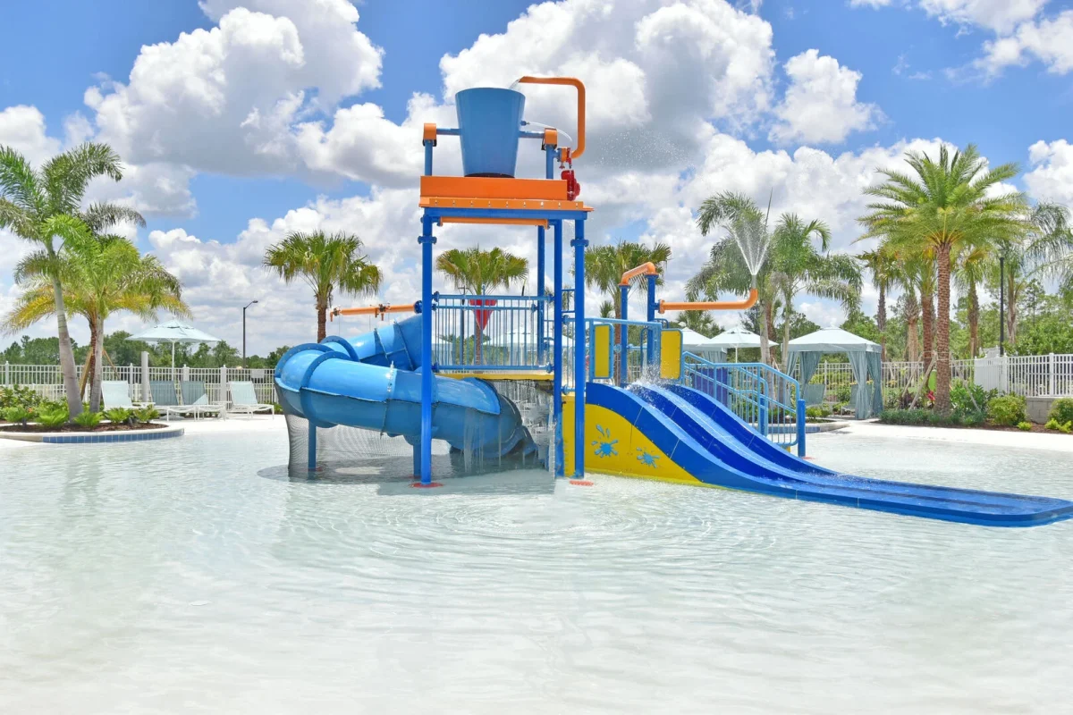 Resort splash pad with water slides and interactive play features surrounded by palm trees in Central Florida. 