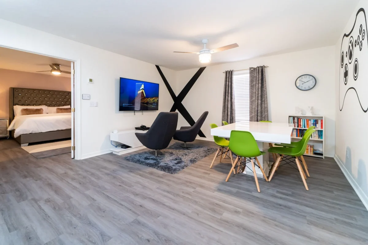 Modern loft style living area with wall mounted TV, dining table, and cozy seating. Perfect for relaxing or family time. 